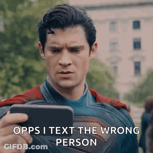 A Man In A Superman Costume Is Holding A Cell Phone And Says " Opps I Text The Wrong Person " . GIF