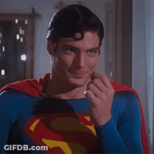 A Man In A Superman Costume Is Making A Gesture With His Finger GIF