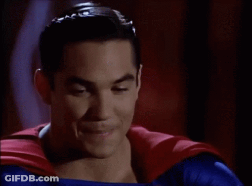 A Man In A Superman Costume Is Smiling For The Camera GIF