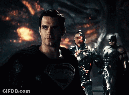 A Man In A Superman Costume Is Standing In Front Of Two Other Superheroes GIF