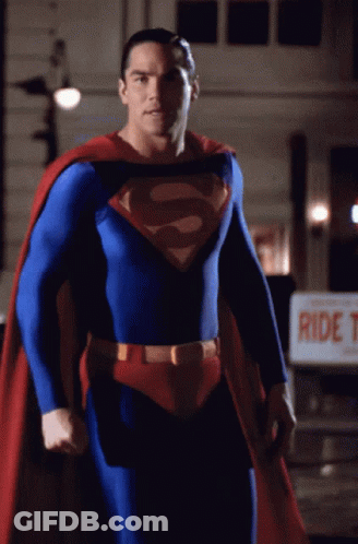 A Man In A Superman Costume Stands In Front Of A Sign That Says Ride T. GIF