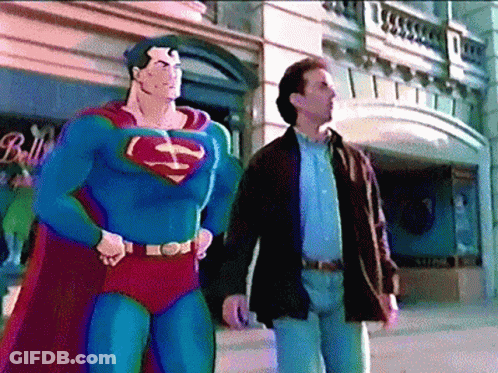 A Man In A Superman Costume Stands Next To A Man In A Brown Jacket GIF