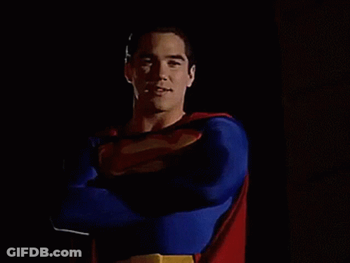 A Man In A Superman Costume Stands With His Arms Crossed GIF