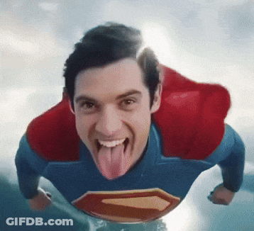 A Man In A Superman Costume With His Tongue Out GIF