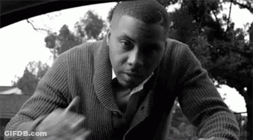 A Man In A Sweater And Tie Is Standing In A Car . GIF