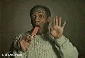 A Man In A Sweater Is Eating An Ice Cream Cone And Making A Funny Face . GIF
