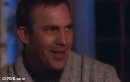 A Man In A Sweater Is Laughing With His Mouth Wide Open GIF