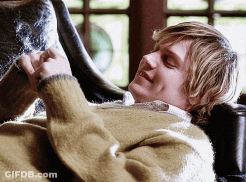 A Man In A Sweater Is Laying On A Chair With The Words Cooperright.tumblr Written Below Him GIF