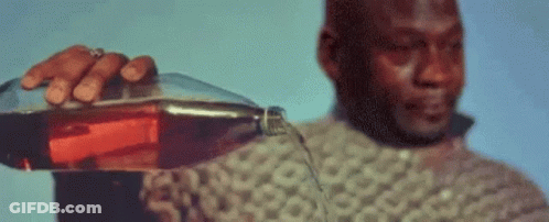 A Man In A Sweater Is Pouring A Bottle Of Coke Into A Glass . GIF