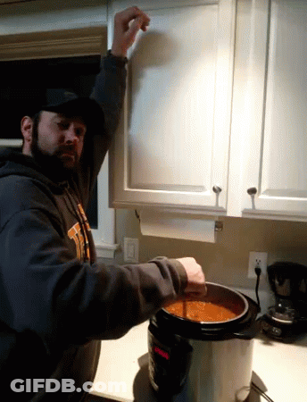 A Man In A Sweatshirt That Says ' Tigers ' On It Is Pouring Soup Into A Pot GIF