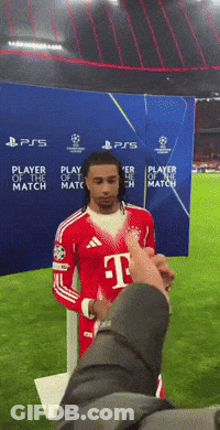 A Man In A T-Mobile Jersey Stands In Front Of A Player Of The Match Banner GIF
