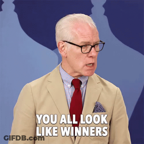 A Man In A Tan Suit And Red Tie Says You All Look Like Winners GIF