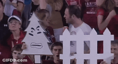 A Man In A Tango Shirt Holds Up A Sign GIF