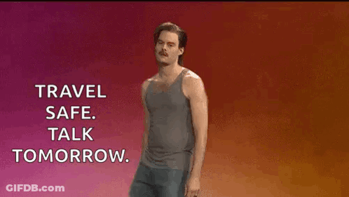 A Man In A Tank Top And Shorts Is Standing In Front Of A Sign That Says Travel Safe Talk Tomorrow GIF