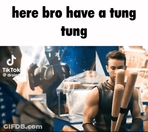 A Man In A Tank Top Is Holding A Pair Of Wooden Bats And Says Here Bro Have A Tung Tung . GIF