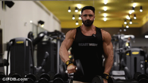 A Man In A Tank Top That Says Beast Mode Is Lifting A Dumbbell GIF