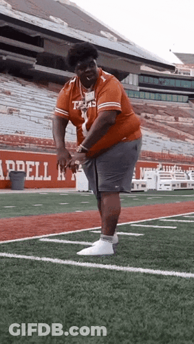 A Man In A Texas Jersey Is Standing On A Football Field GIF