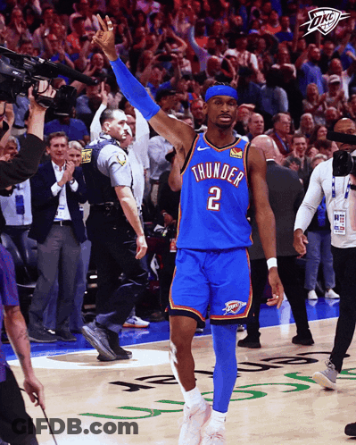 A Man In A Thunder Jersey Stands On The Court With His Arms In The Air GIF