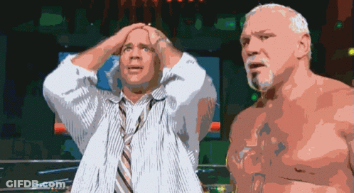 A Man In A Tie Holds His Head While Another Man Looks On GIF