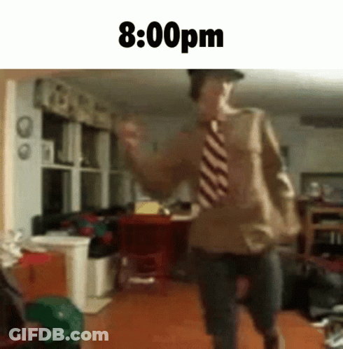 A Man In A Tie Is Dancing In A Living Room With The Time Of 8:00 Pm GIF