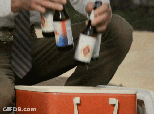 A Man In A Tie Is Holding Two Bottles Of Beer GIF