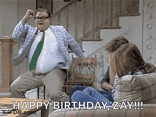 A Man In A Tie Is Jumping In The Air While A Woman Sits On A Couch And Says Happy Birthday Zay !!! GIF