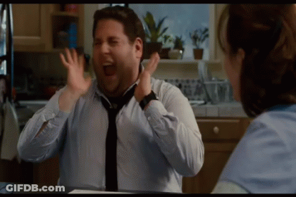 A Man In A Tie Is Laughing In A Kitchen GIF