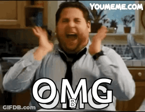 A Man In A Tie Is Making A Funny Face With His Hands In The Air And The Words Omg B On His Chest . GIF