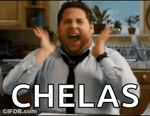 A Man In A Tie Is Screaming In A Kitchen With The Word Chelas Above Him GIF