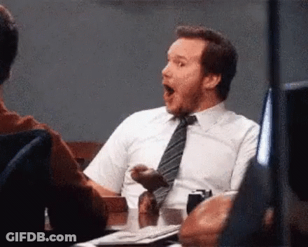 A Man In A Tie Is Sitting At A Table With His Mouth Open . GIF