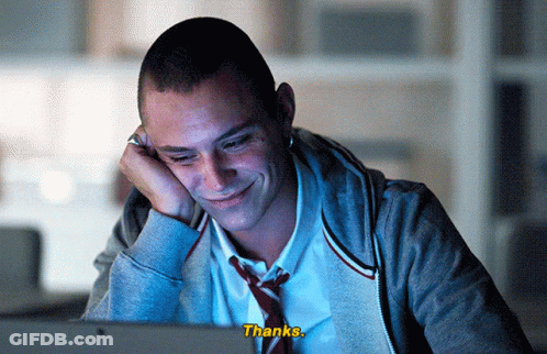 A Man In A Tie Is Smiling While Looking At A Computer Screen And The Words Thanks Are Visible GIF