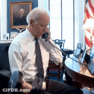 A Man In A Tie Is Talking On A Phone GIF