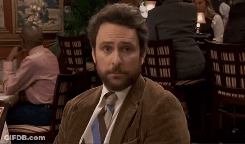 A Man In A Tie Sits At A Table With A Bottle Of Beer On It GIF