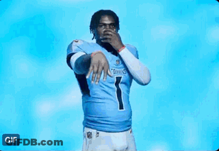 A Man In A Titans Jersey Is Standing In Front Of A Blue Light . GIF