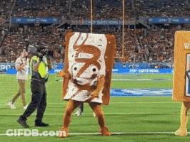 A Man In A Toaster Pastries Costume Is Walking On A Football Field GIF