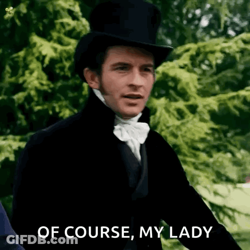 A Man In A Top Hat And Bow Tie Is Standing In Front Of Trees . GIF