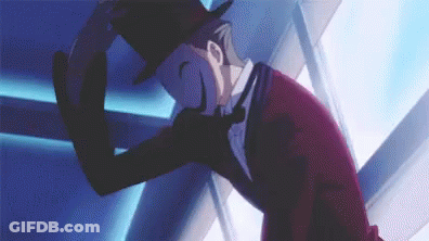 A Man In A Top Hat And Suit Is Standing In Front Of A Blue Wall . GIF