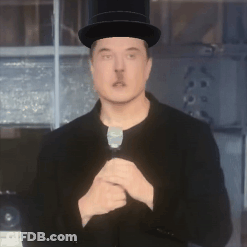 A Man In A Top Hat Holds A Microphone In His Hand GIF