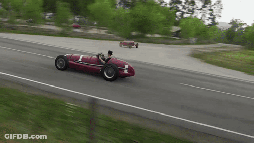 A Man In A Top Hat Is Driving A Red Race Car With The Number 1 On It GIF