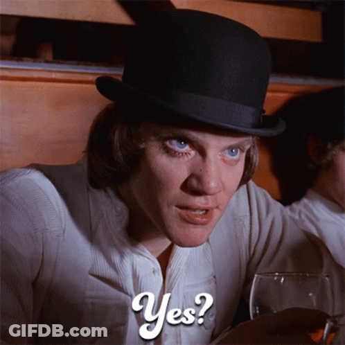 A Man In A Top Hat Is Holding A Glass Of Wine And Says Yes GIF