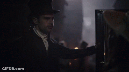 A Man In A Top Hat Is Looking At Something GIF