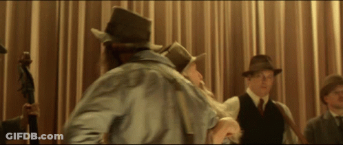 A Man In A Top Hat Stands In Front Of A Curtain GIF