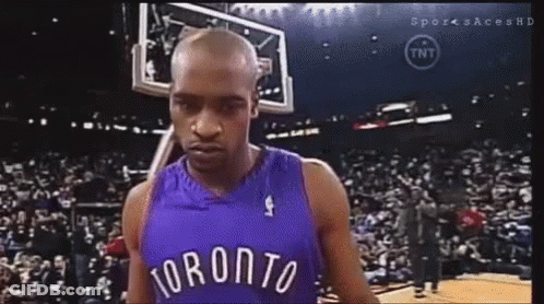 A Man In A Toronto Jersey Is Standing In Front Of A Crowd . GIF