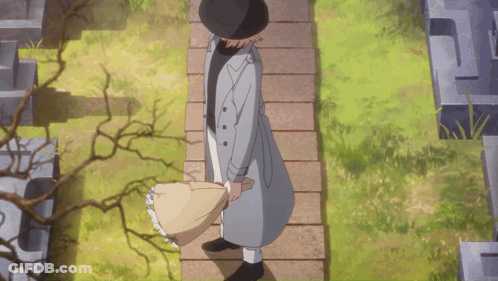 A Man In A Trench Coat And Hat Is Walking Down A Stone Path GIF