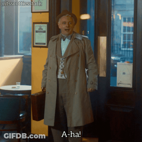 A Man In A Trench Coat Holding A Briefcase Says " A-Ha " GIF