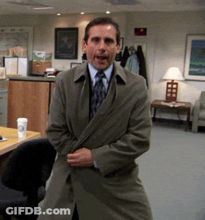 A Man In A Trench Coat Is Standing In A Room GIF