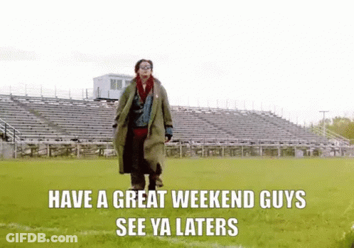 A Man In A Trench Coat Is Walking On A Field With A Stadium In The Background . GIF