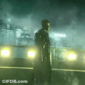 A Man In A Trench Coat Stands In Front Of A City Skyline At Night GIF