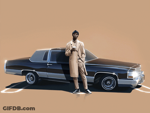A Man In A Trench Coat Stands In Front Of A Low Rider Car GIF
