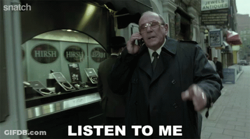 A Man In A Trench Coat Talking On A Cell Phone With The Words Listen To Me Above Him GIF